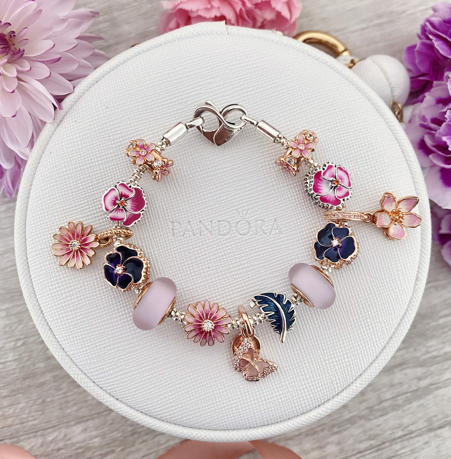 Gold bracelet made up of pink and purple flower shaped charms