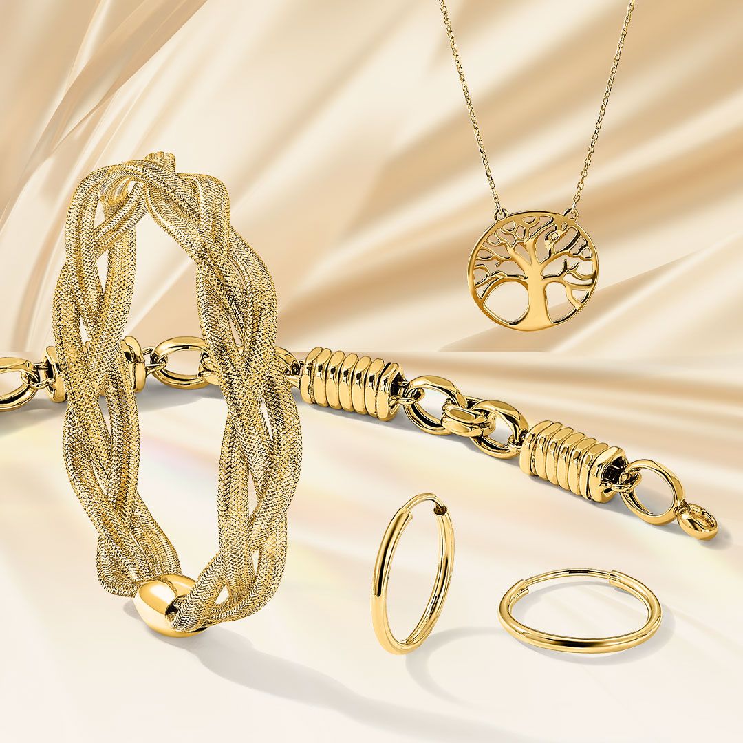 A collection of Quality Gold products including a golden bracelet, earrings, chain, and necklace with a cream colored silk backdrop